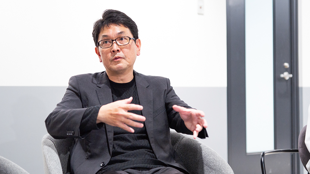 手でジェスチャーを入れながら話す丸岩さんの写真